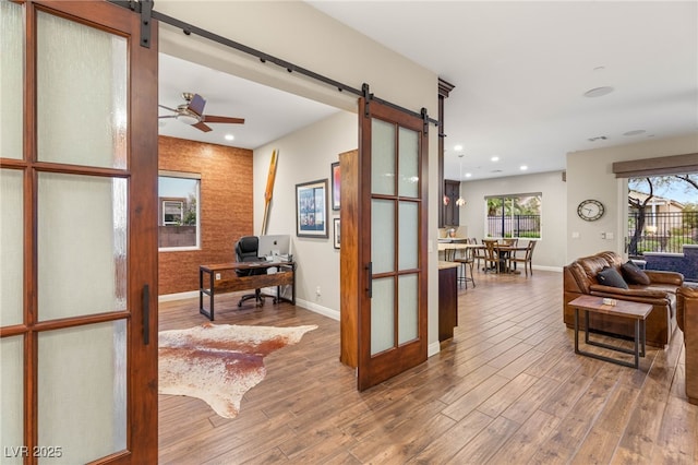 2116 Canvas Edge Dr, Henderson, NV 89044 - hall with a barn door, an office area, baseboards, wood finished floors, and recessed lighting