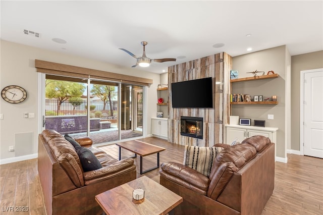 2116 Canvas Edge Dr, Henderson, NV 89044 - living room featuring baseboards, light wood-style flooring, a large fireplace, ceiling fan, and recessed lighting