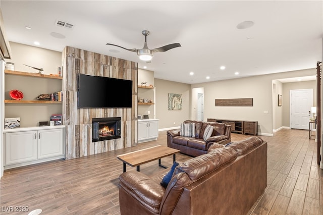 2116 Canvas Edge Dr, Henderson, NV 89044 - living area with light wood-style flooring, a fireplace, ceiling fan, recessed lighting, and baseboards