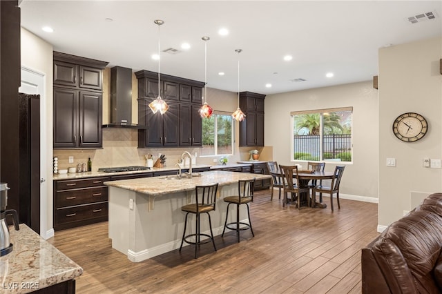 2116 Canvas Edge Dr, Henderson, NV 89044 - kitchen featuring wall chimney exhaust hood, gas cooktop, a sink, wood finished floors, and backsplash