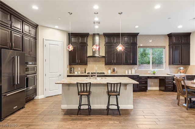 2116 Canvas Edge Dr, Henderson, NV 89044 - kitchen featuring stainless steel appliances, wall chimney exhaust hood, light wood-type flooring, backsplash, and recessed lighting