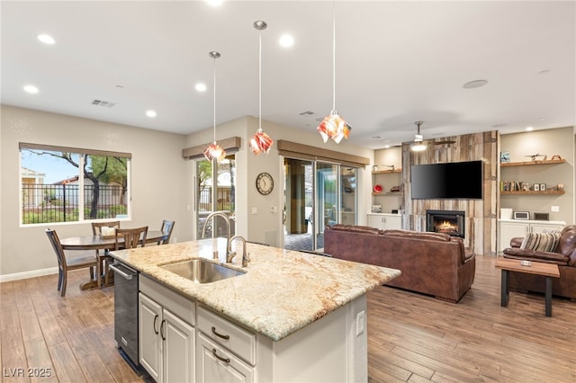 2116 Canvas Edge Dr, Henderson, NV 89044 - kitchen with a sink, light wood-type flooring, light stone countertops, a fireplace, and recessed lighting