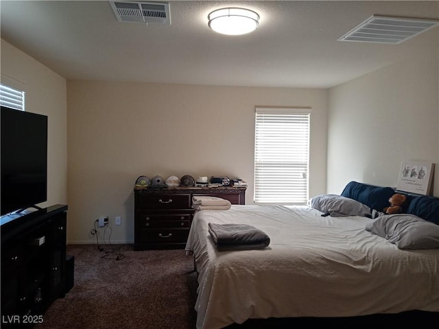 bedroom with dark colored carpet and baseboards