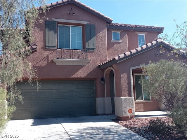 mediterranean / spanish-style house with a tiled roof, driveway, an attached garage, and stucco siding