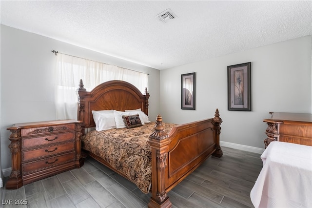 bedroom featuring baseboards and a textured ceiling