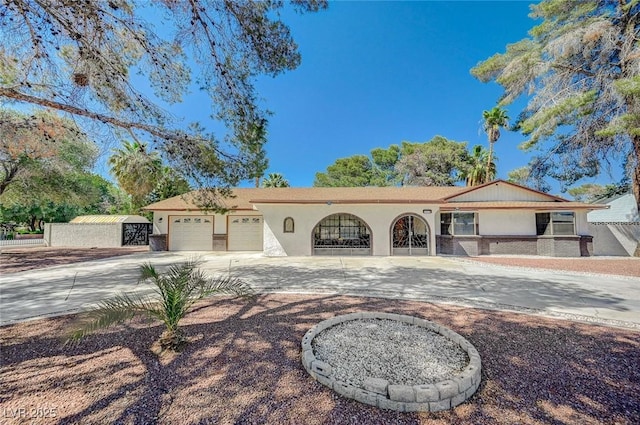 ranch-style home with concrete driveway, an attached garage, and stucco siding