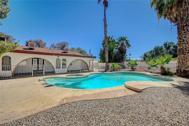 view of swimming pool with a fenced backyard, a patio area, central AC unit, and an in-ground hot tub