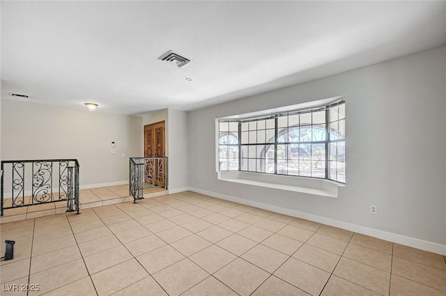 empty room featuring tile patterned floors and baseboards