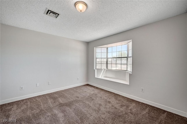 carpeted empty room with baseboards and a textured ceiling