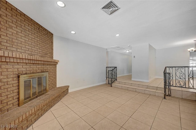 unfurnished living room featuring light tile patterned floors, recessed lighting, a fireplace, baseboards, and a chandelier