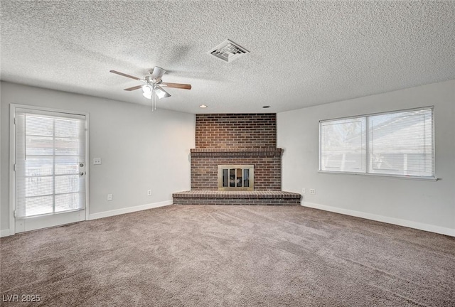 unfurnished living room featuring ceiling fan, carpet floors, a brick fireplace, a textured ceiling, and baseboards