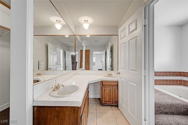 bathroom featuring double vanity, tile patterned flooring, and a bath