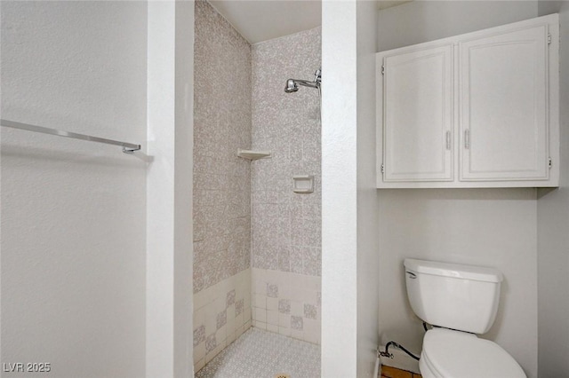 full bathroom featuring a stall shower and toilet