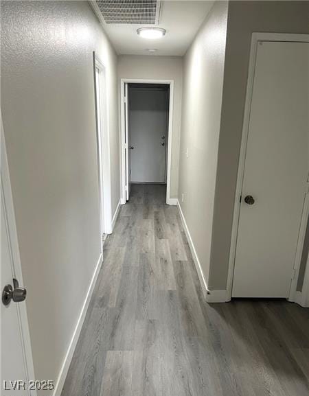 hallway with wood finished floors and baseboards