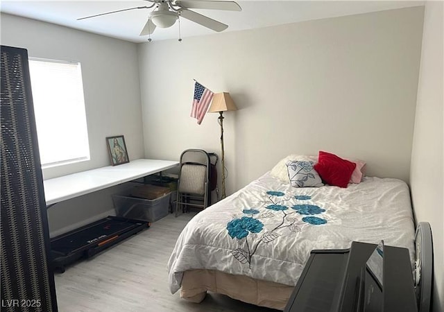 bedroom featuring wood finished floors, a desk, and ceiling fan