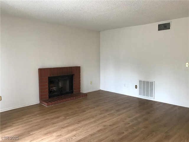 3138 White Rose Way, Henderson, NV 89014 - unfurnished living room featuring wood finished floors, a brick fireplace, and a textured ceiling