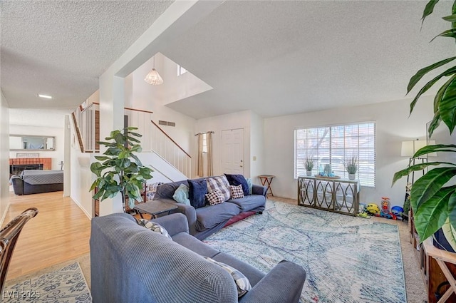 3138 White Rose Way, Henderson, NV 89014 - living area with a textured ceiling, stairs, a fireplace, and wood finished floors
