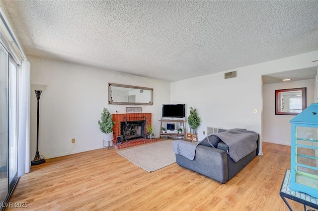 3138 White Rose Way, Henderson, NV 89014 - living room featuring light wood-style flooring, a textured ceiling, plenty of natural light, and a brick fireplace