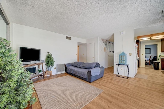 3138 White Rose Way, Henderson, NV 89014 - living area featuring light wood-style flooring, a textured ceiling, and stairway