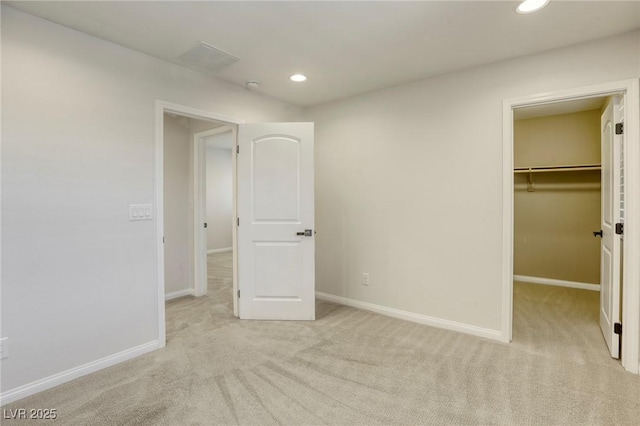 unfurnished bedroom featuring carpet floors, recessed lighting, baseboards, and a spacious closet