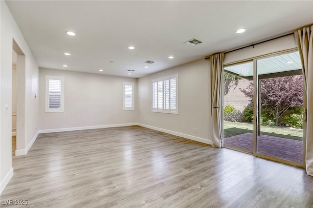 empty room featuring light wood finished floors, baseboards, and recessed lighting