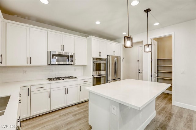 kitchen with appliances with stainless steel finishes, light wood-style flooring, white cabinets, and recessed lighting