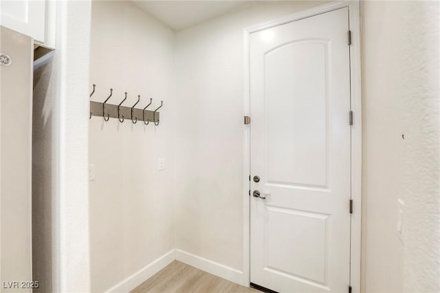 doorway with light wood-style flooring and baseboards