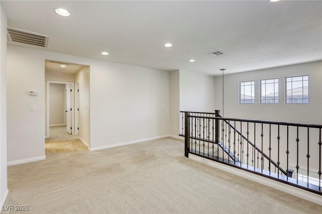 spare room featuring carpet flooring, recessed lighting, and baseboards