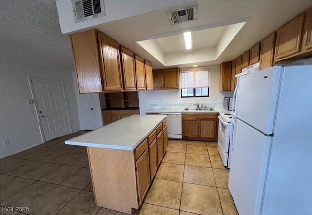 101 Luna Way Unit 145, Las Vegas, NV 89145 - kitchen featuring white appliances, a sink, a tray ceiling, light countertops, and light tile patterned floors
