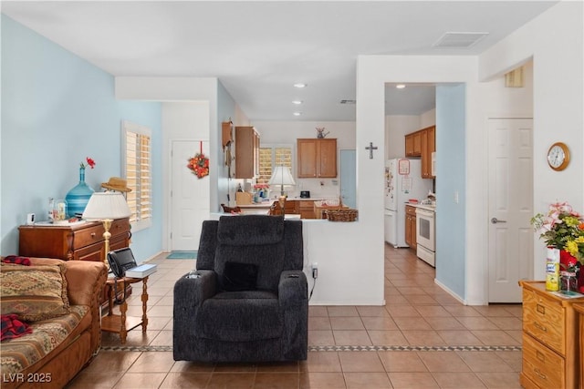 living area with light tile patterned flooring, recessed lighting, and baseboards