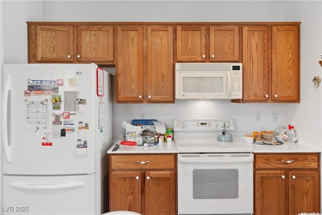 kitchen featuring white appliances, brown cabinets, and light countertops
