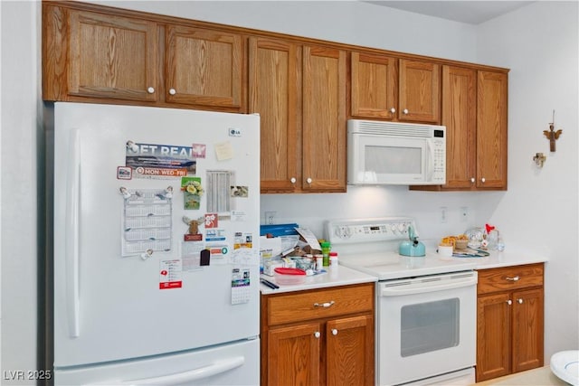 kitchen featuring white appliances, brown cabinets, and light countertops