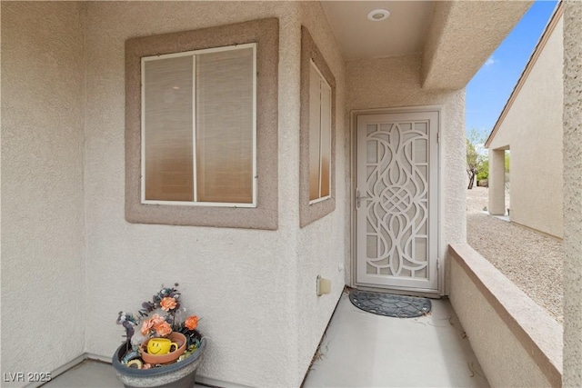 doorway to property featuring stucco siding