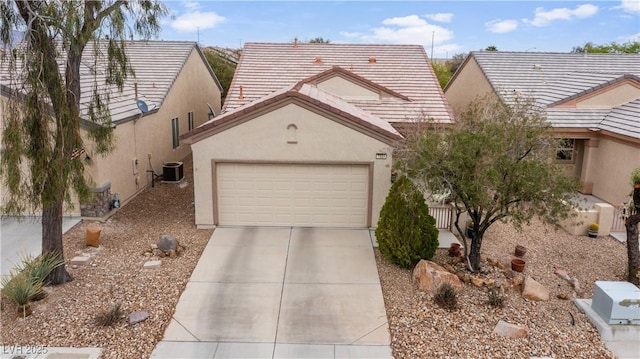 view of front of property with stucco siding, concrete driveway, an attached garage, central AC unit, and a tile roof