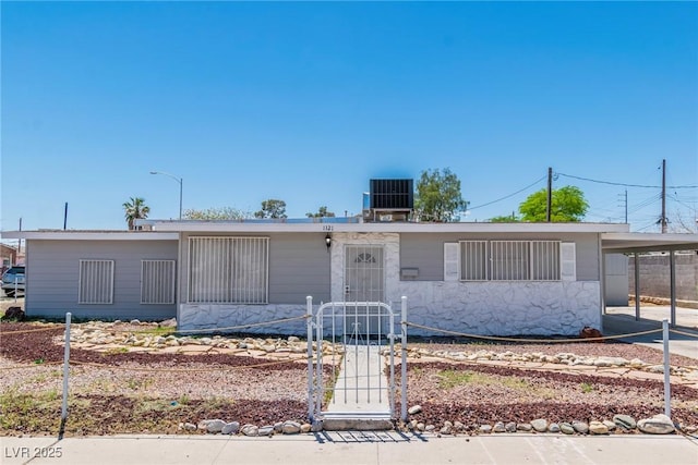 view of front of house with central air condition unit, a carport, a gate, and a fenced front yard
