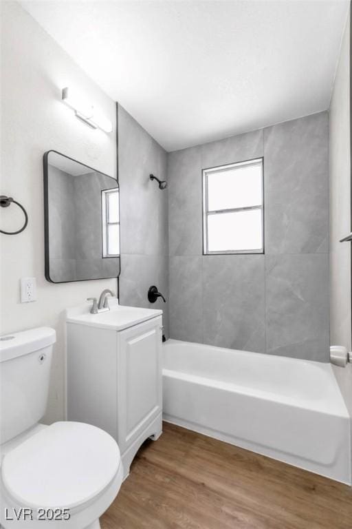 bathroom with bathtub / shower combination, wood finished floors, toilet, and vanity