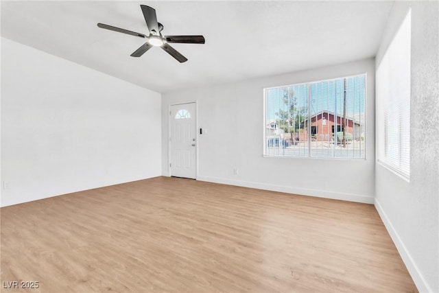 unfurnished living room with light wood-style floors, a ceiling fan, and baseboards