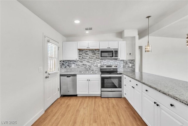 kitchen featuring appliances with stainless steel finishes, tasteful backsplash, light wood-style flooring, white cabinetry, and recessed lighting