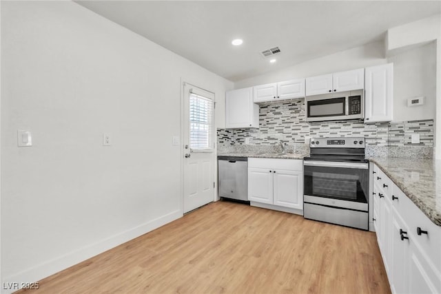 kitchen with stainless steel appliances, white cabinets, backsplash, and recessed lighting