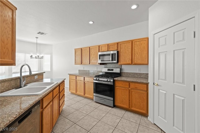 2333 Silver Crew Pass, Henderson, NV 89052 - kitchen with appliances with stainless steel finishes, a sink, a chandelier, light tile patterned flooring, and pendant lighting