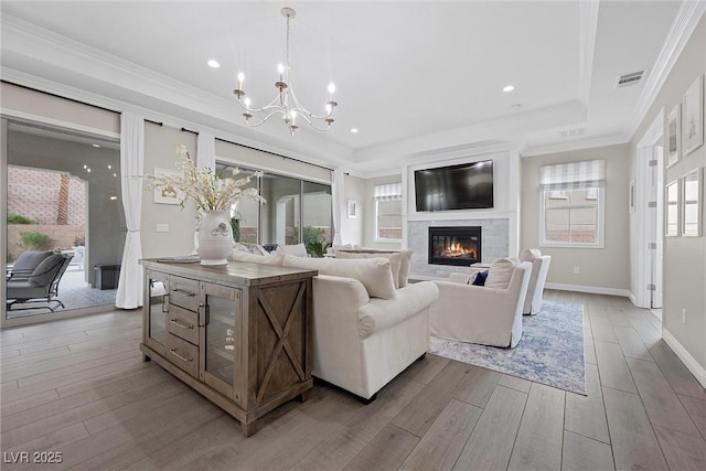 4220 San Alivia Ct, Las Vegas, NV 89141 - living area featuring a chandelier, wood finished floors, a high end fireplace, a tray ceiling, and baseboards