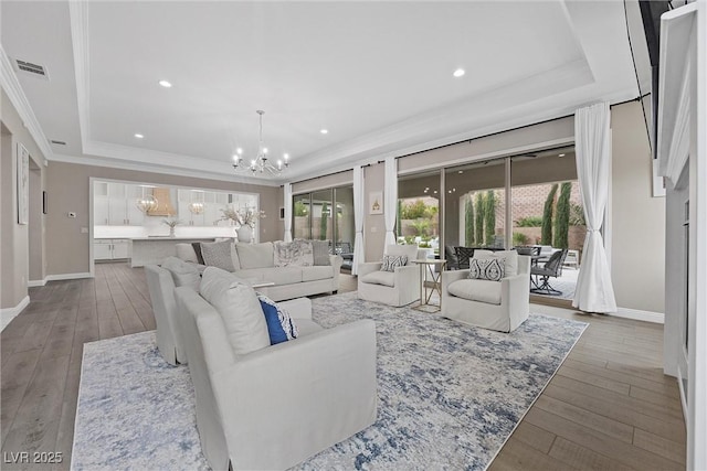 4220 San Alivia Ct, Las Vegas, NV 89141 - living room with a tray ceiling, a chandelier, wood-type flooring, crown molding, and baseboards
