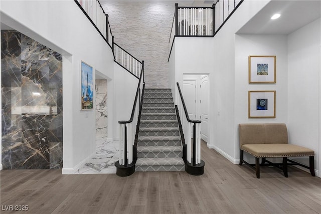 4220 San Alivia Ct, Las Vegas, NV 89141 - stairs featuring wood finished floors, a towering ceiling, and baseboards