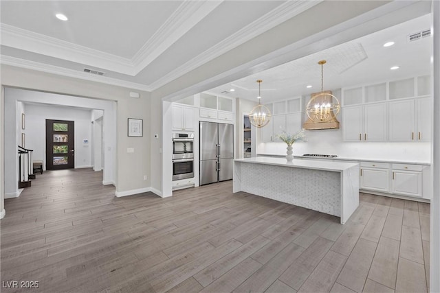 4220 San Alivia Ct, Las Vegas, NV 89141 - kitchen featuring stainless steel appliances, a raised ceiling, a chandelier, white cabinetry, and light wood finished floors