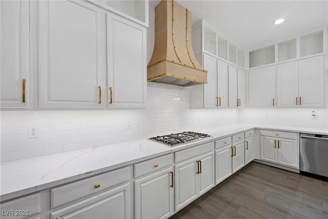 4220 San Alivia Ct, Las Vegas, NV 89141 - kitchen featuring custom exhaust hood, stainless steel appliances, white cabinets, dark wood-style flooring, and light stone counters