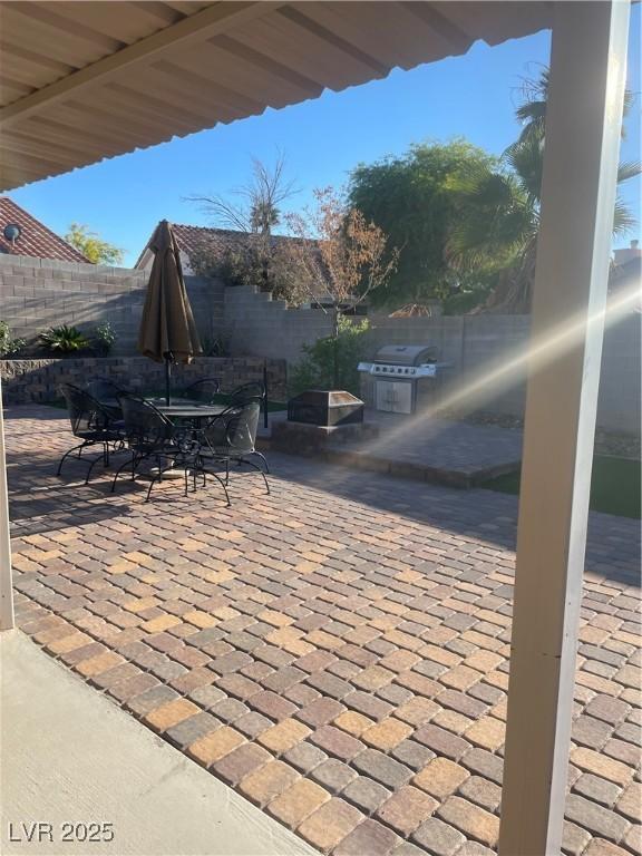 view of patio with a fenced backyard, a grill, and outdoor dining area