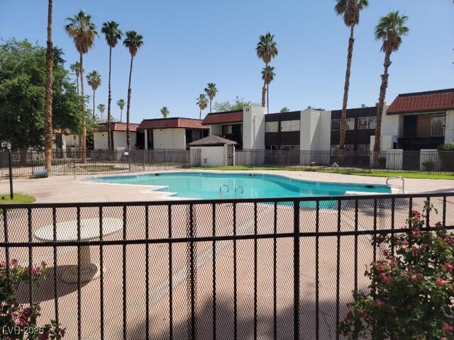 community pool with fence and a patio