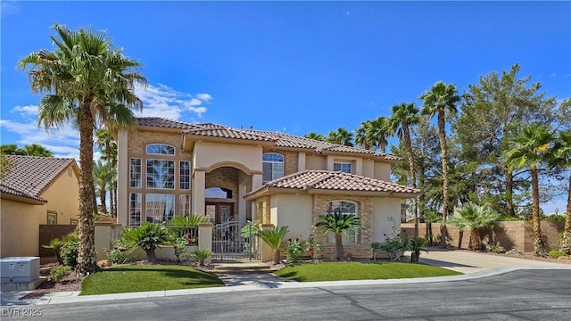 5445 Pendini Point Ct, Las Vegas, NV 89141 - mediterranean / spanish-style house featuring a fenced front yard, stucco siding, a tiled roof, a gate, and stone siding