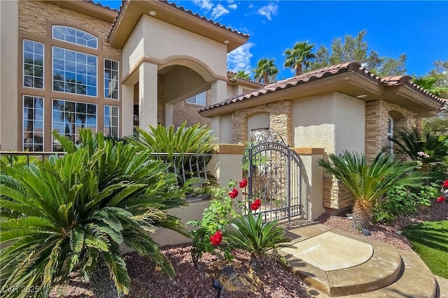 5445 Pendini Point Ct, Las Vegas, NV 89141 - property entrance featuring stucco siding, a tile roof, stone siding, and a gate