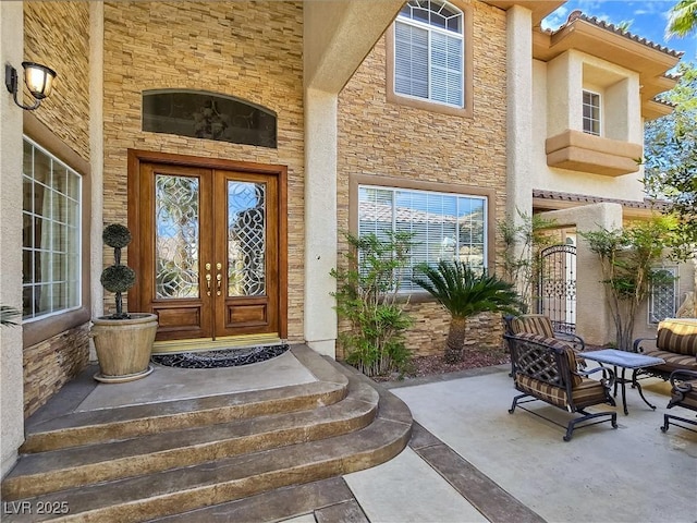 5445 Pendini Point Ct, Las Vegas, NV 89141 - view of exterior entry featuring french doors, stone siding, and stucco siding